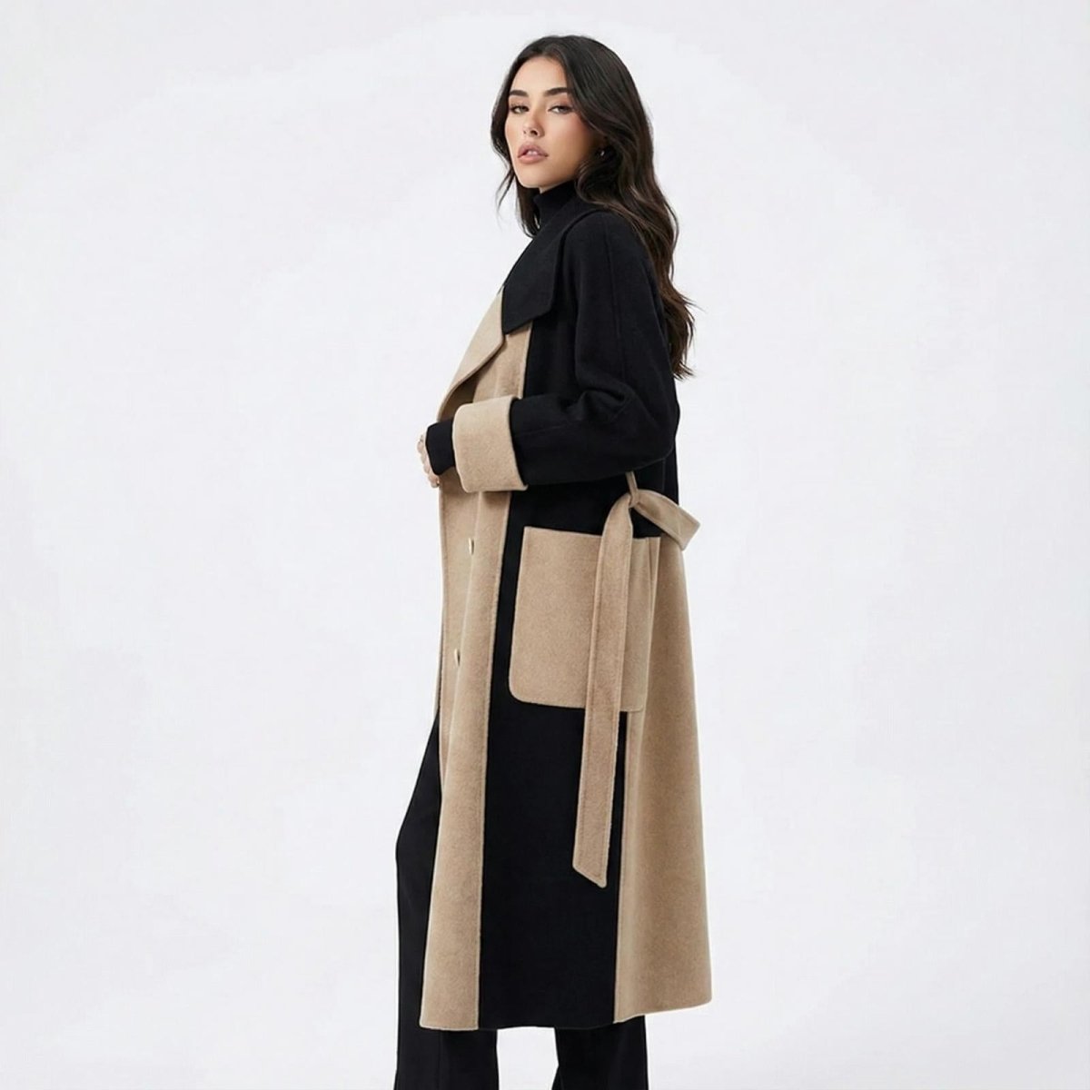 Madison Beer wearing the Madison two-tone long wool coat in camel and black from Kouvr Fashion, shown in a side profile with a tie belt.