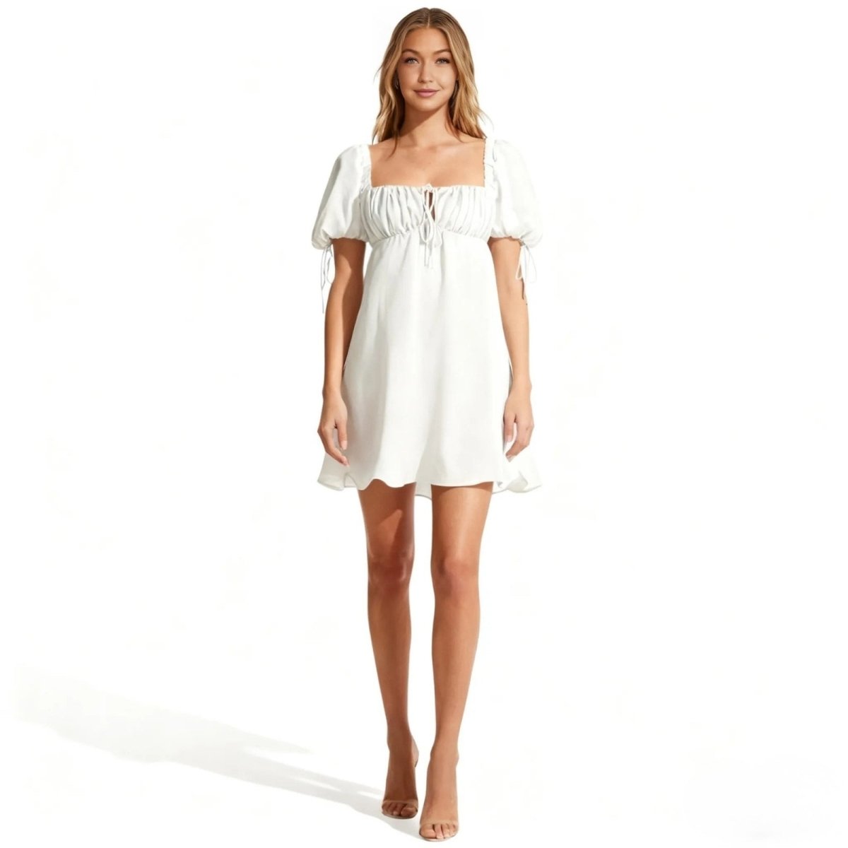 Woman wearing a white Kouvr off-shoulder dress on a white background