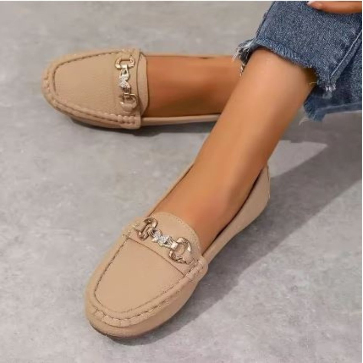 Close-up of a woman wearing Kouvr Mildred khaki leather loafers, paired with casual denim for an elegant look.