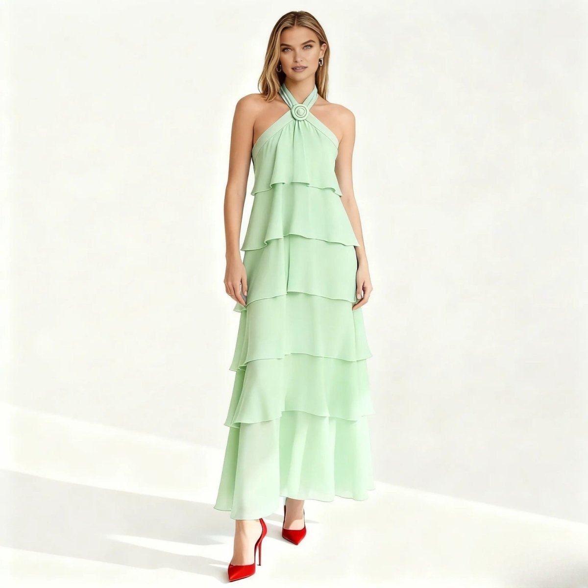 Woman wearing a light green Kouvr tiered dress on a white background