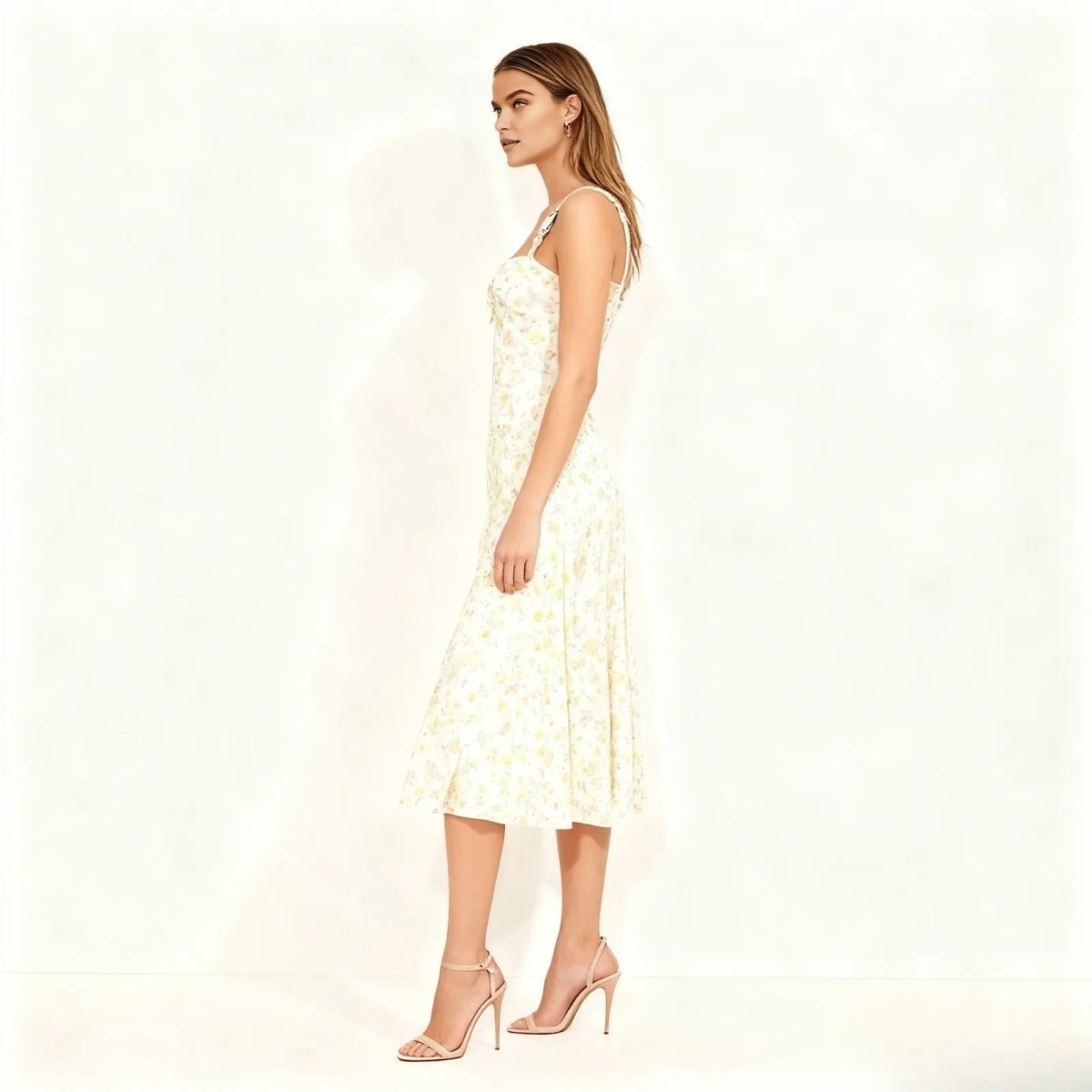 Side profile of a model in the Kouvr Fashion ivory A-line midi dress, showcasing its fit and flare silhouette.