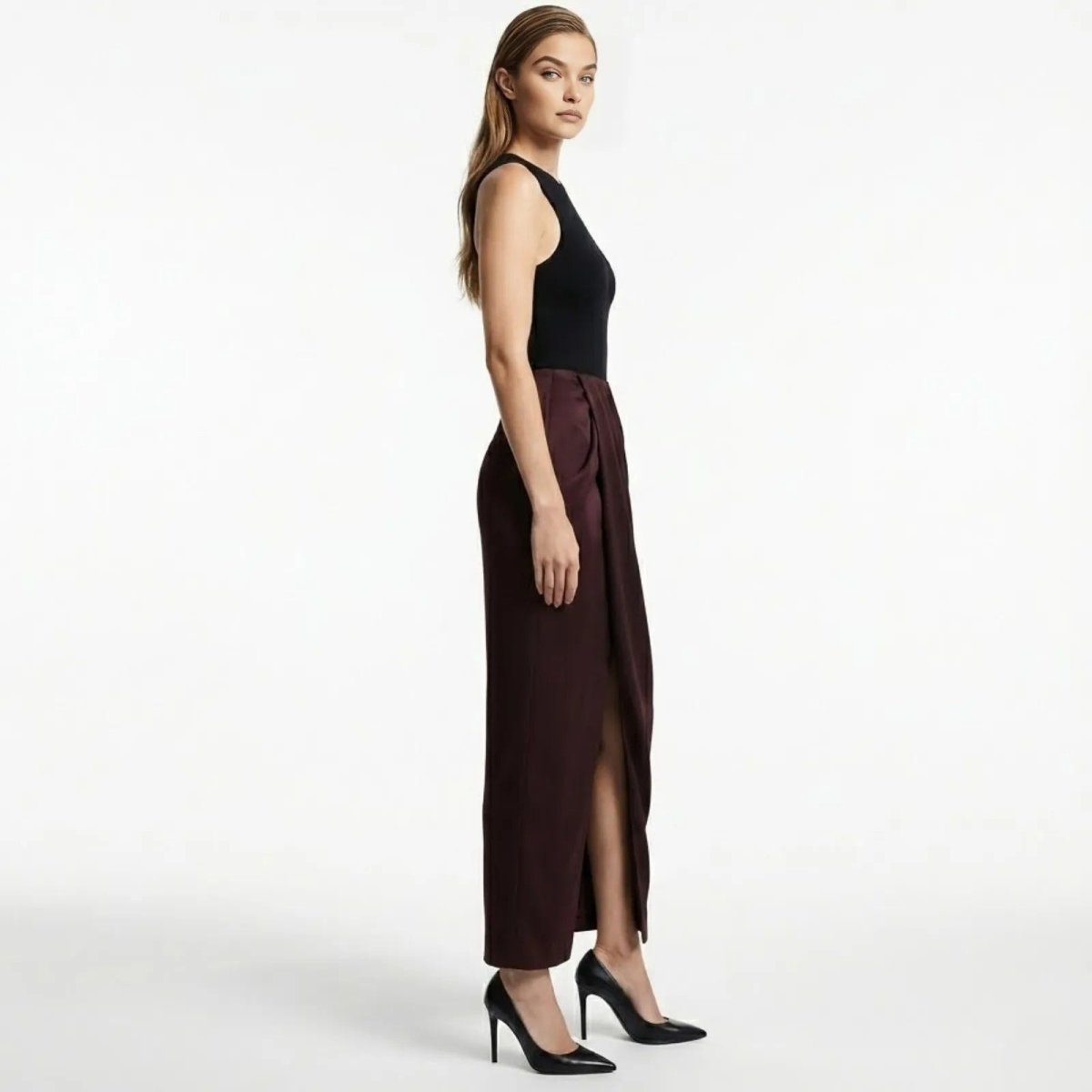 Side profile of the Ourania aubergine draped trousers showing the asymmetrical wrap and leg slit detail.