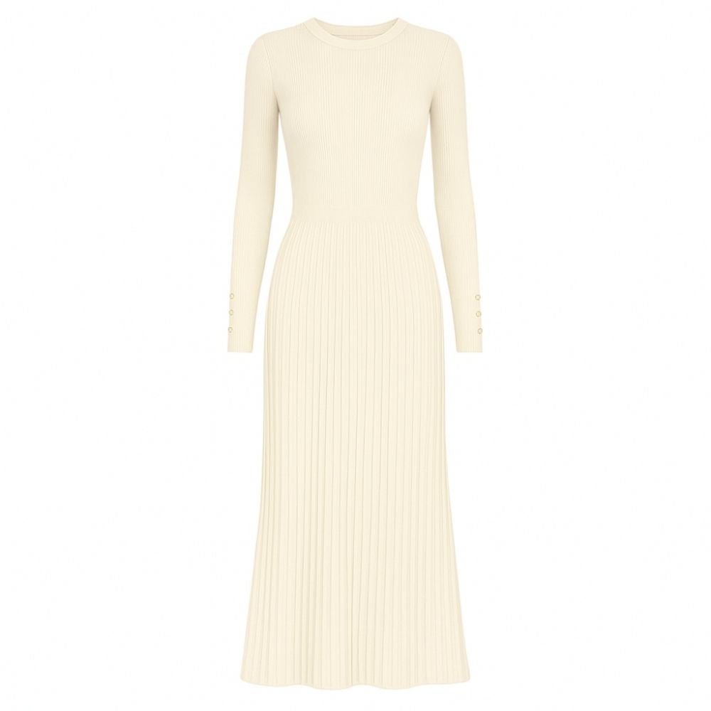 Model wearing the Kouvr Fashion long sleeve pleated knit maxi dress in cream, posing in a minimalist room