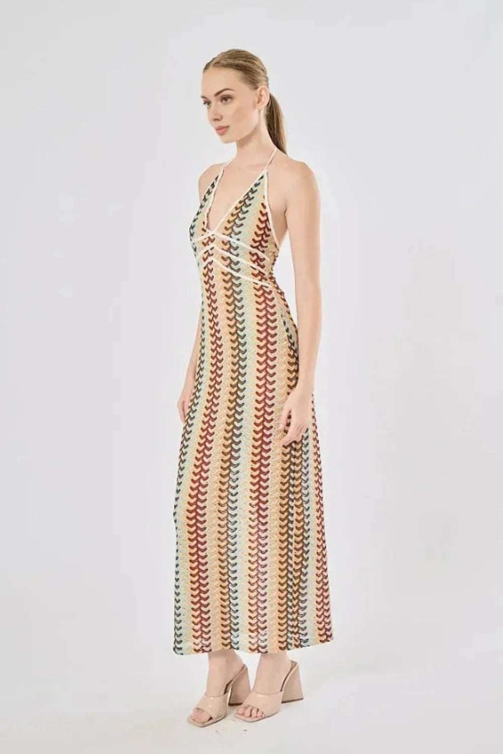 Model viewed from the back wearing the Kouvr Fashion 70s-inspired retro wave print halter maxi dress, showcasing the open-back design