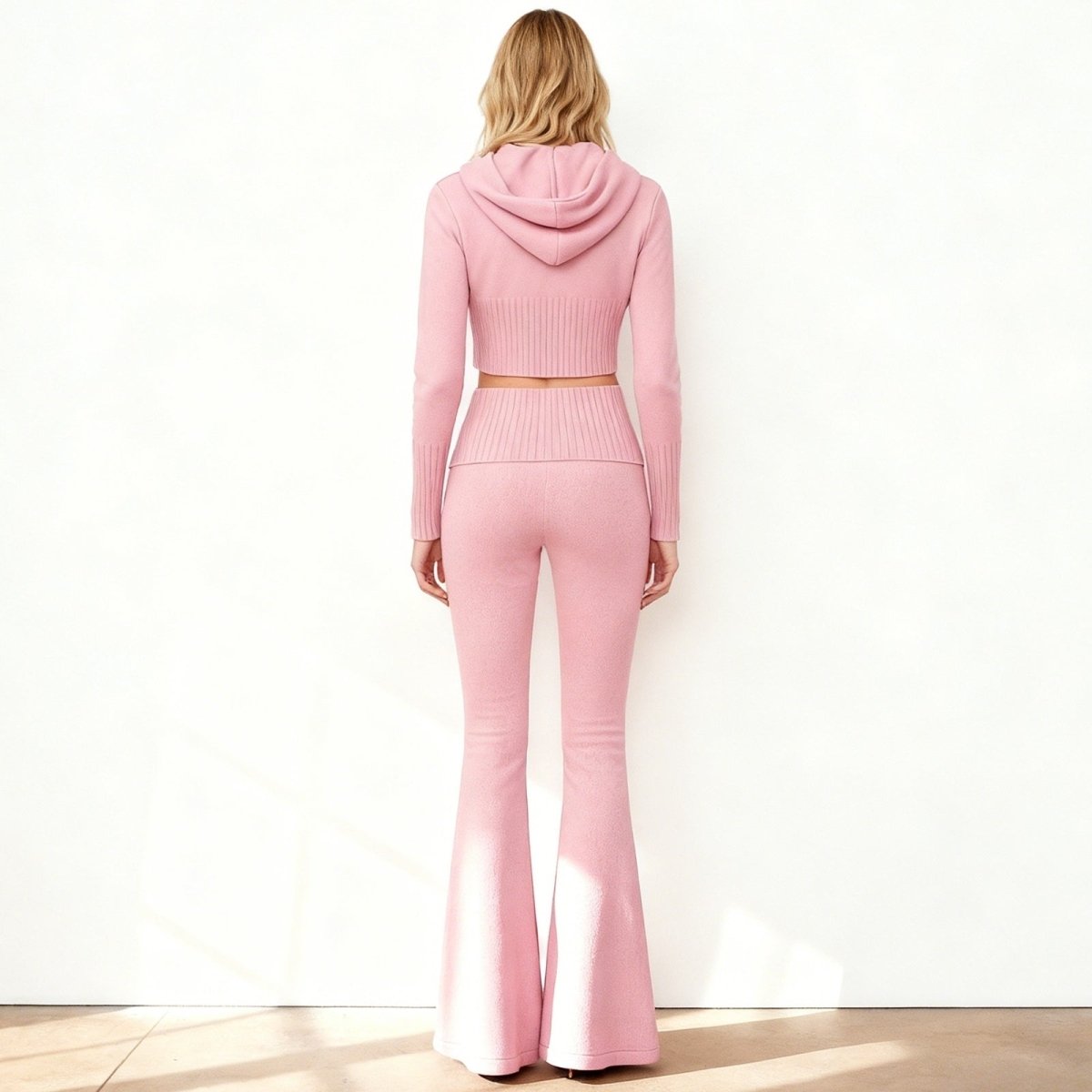 Back view of the Kouvr Fashion rose quartz knit set, showing the detailed ribbed texture on the hoodie and waistband of the flared pants.