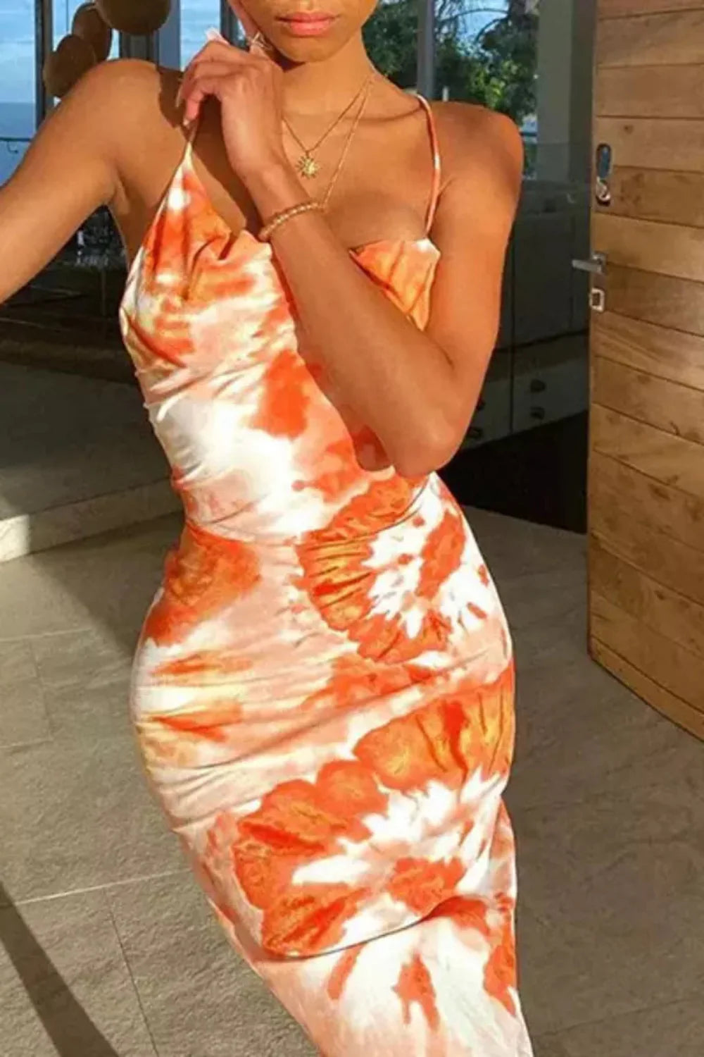 Model wearing the Kouvr Fashion Sunset Orange Tie-Dye Slip Dress with backless lace-up detail