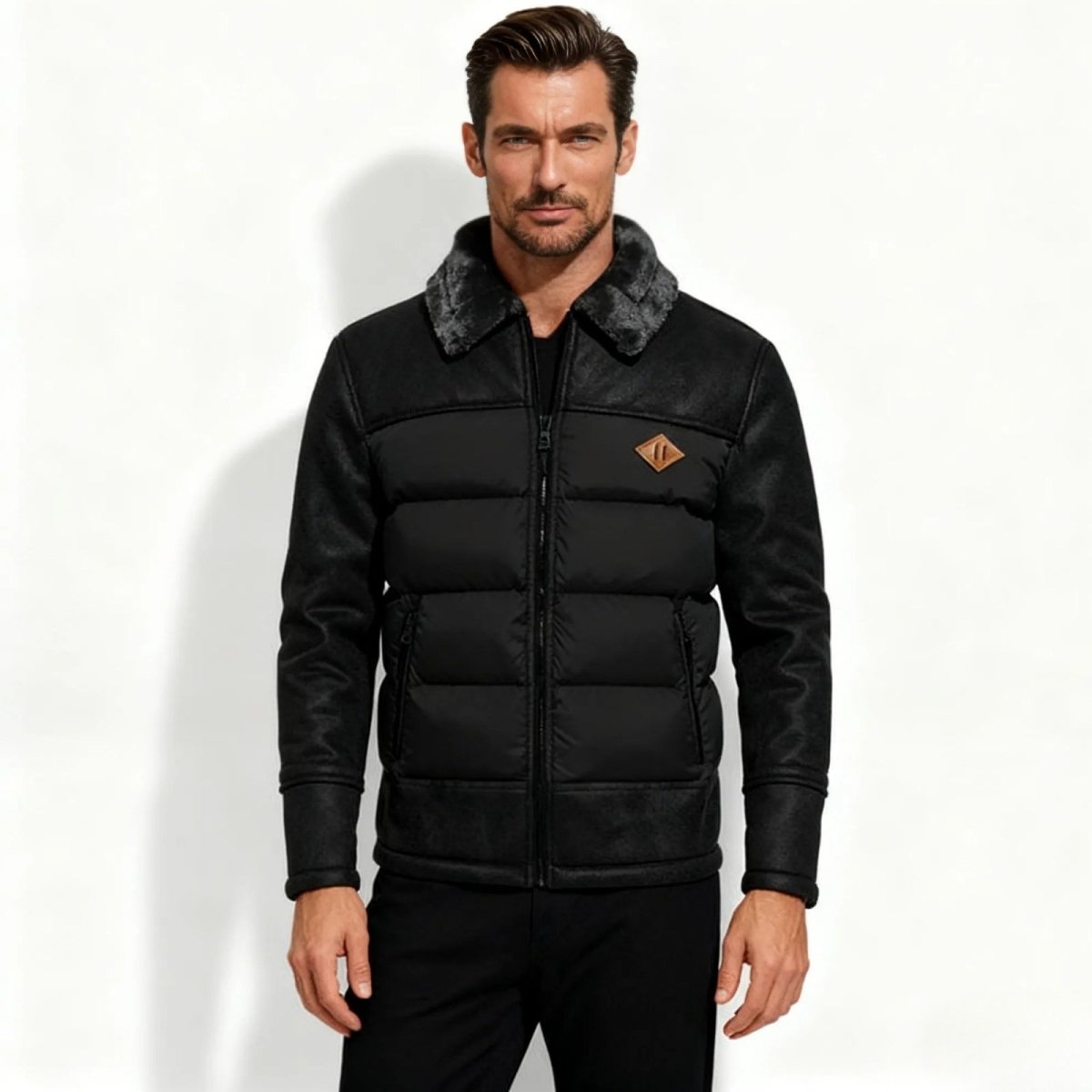 Man wearing a black Kouvr puffer jacket with a gray fur collar on a white background