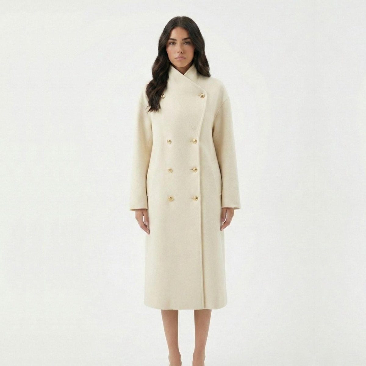 Madison Beer is wearing the Kouvr Fashion Maddie long ivory wool coat, fully buttoned to show the high collar and double-breasted silhouette against a white background.