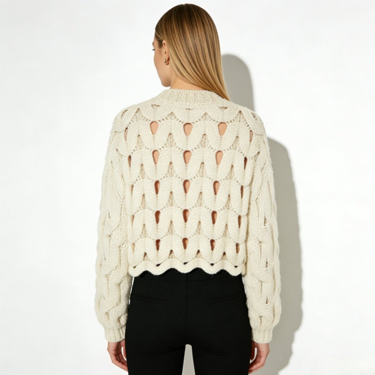 Back view of the Kouvr Fashion Vanice open-knit sweater showcasing the continuous wave cutout pattern.