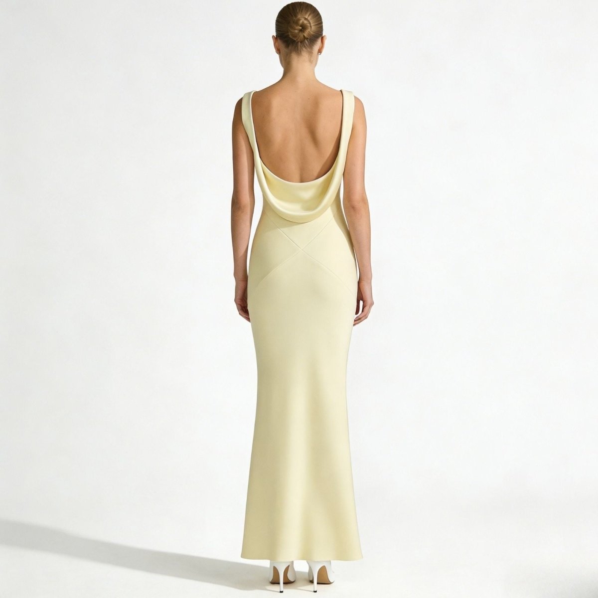 Back view of the Kouvr Fashion Vickie Gown, highlighting the dramatic low draped backless design and X-seam detail of the ivory satin formal dress.
