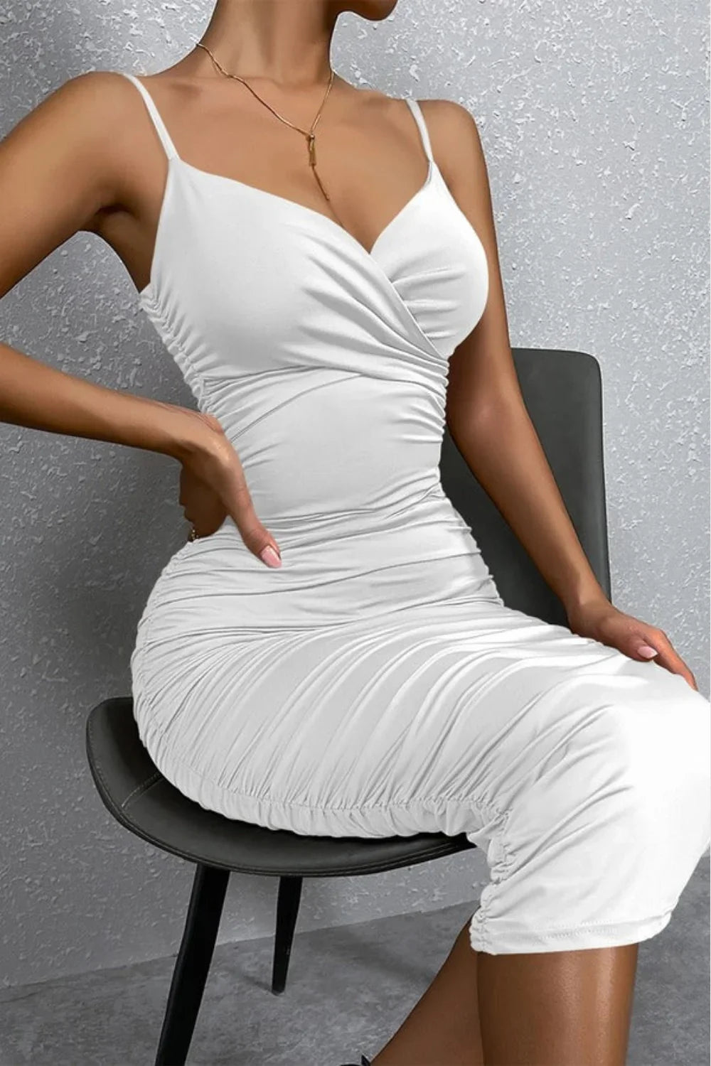 Model wearing Kouvr Fashion's white ruched bodycon midi dress, standing with hands on hips to showcase the hourglass fit