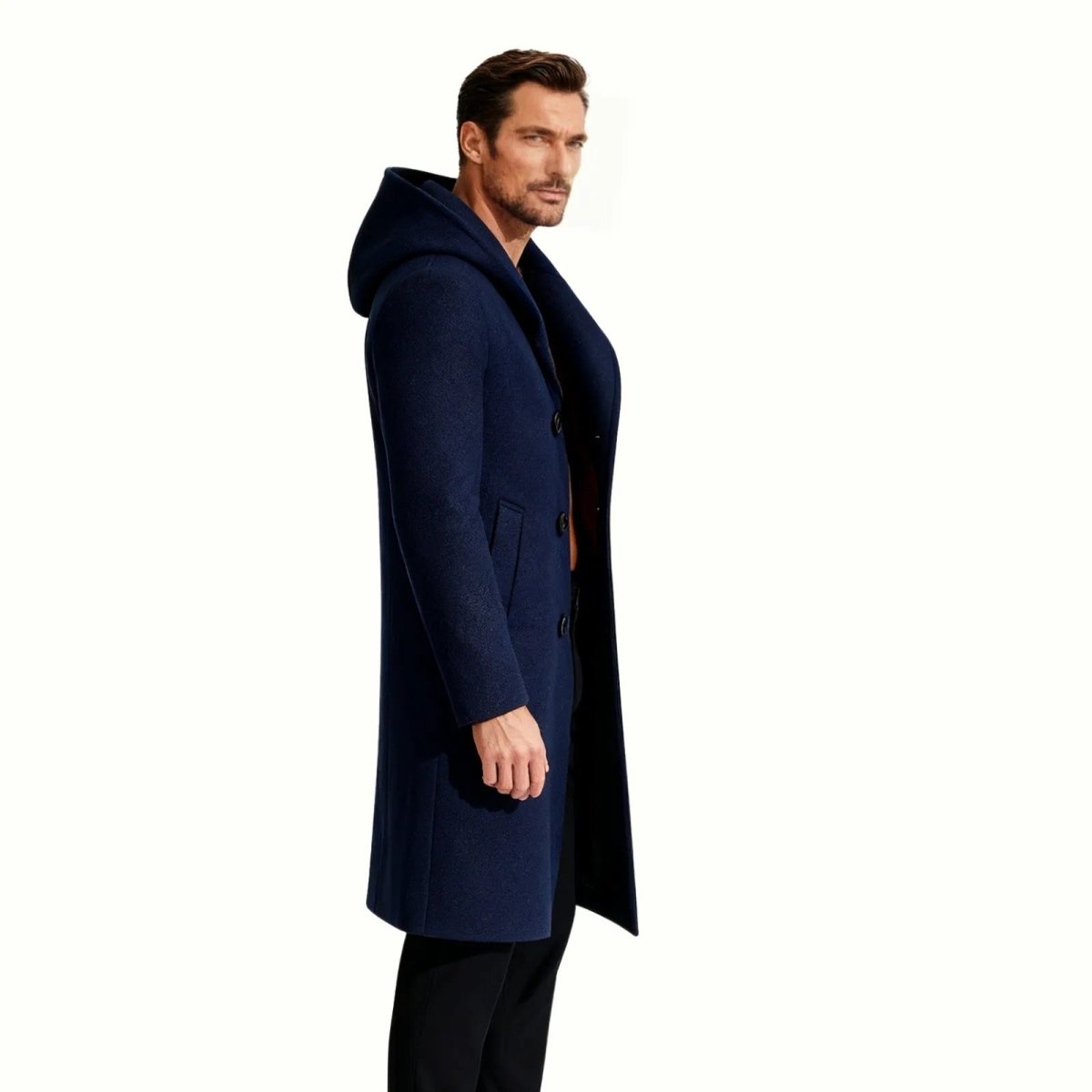 Male model in a side profile view wearing the Kouvr Fashion navy blue hooded wool overcoat, showcasing its tailored fit.