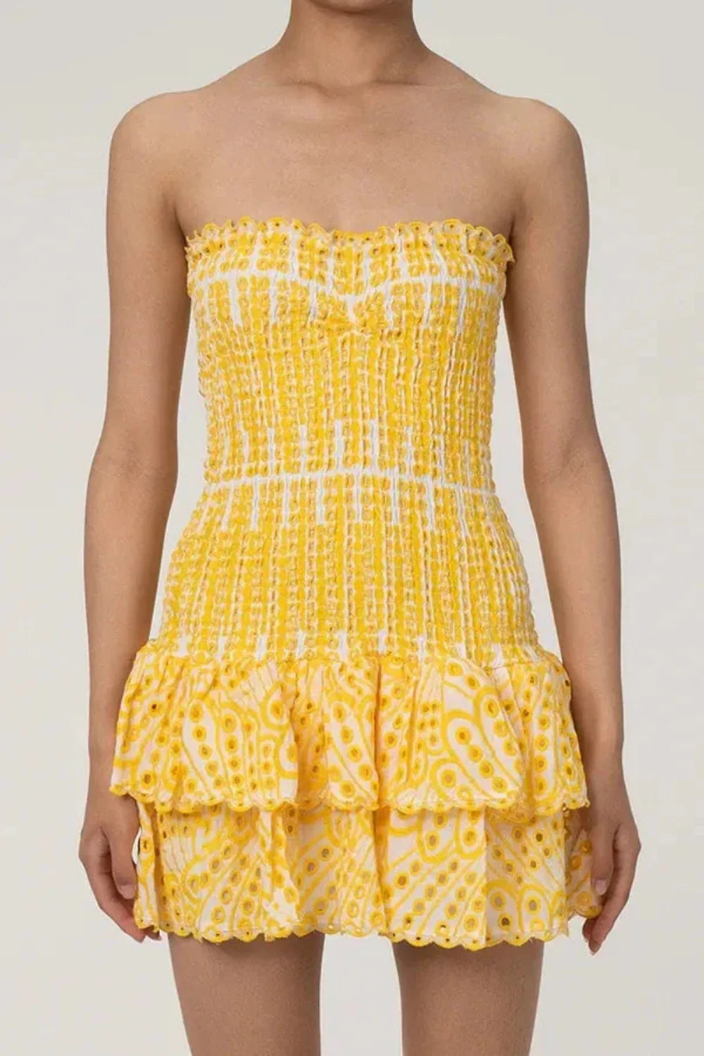 Model wearing Kouvr Fashion strapless yellow eyelet mini dress with tiered ruffle skirt