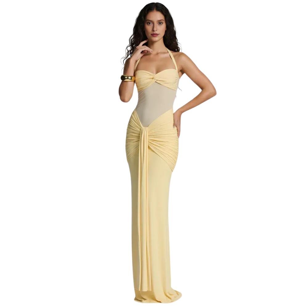 Model wearing the Kouvr Fashion yellow halter neck maxi gown with sheer midriff panel and draped skirt