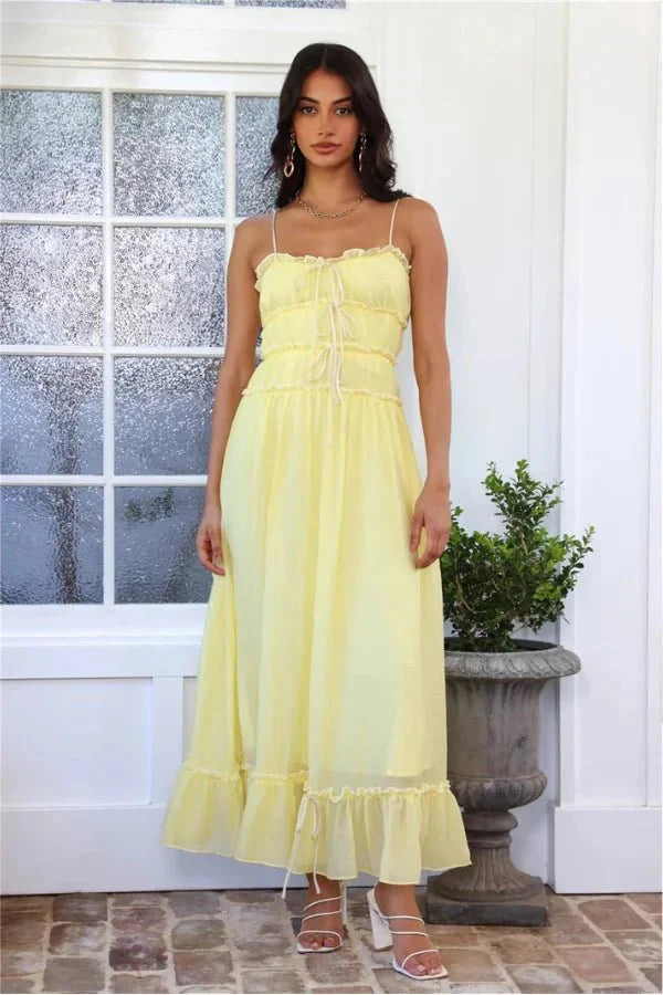 Model wearing the Kouvr Fashion Yoona Yellow Ruffle Midi Dress in a sunlit room