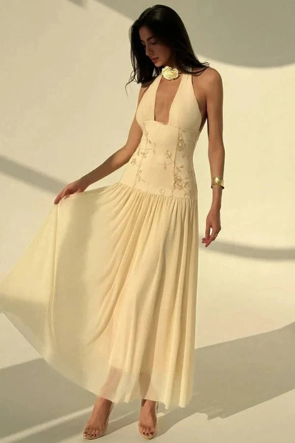 Model wearing the Kouvr Fashion Zoe yellow embroidered halter gown with open back