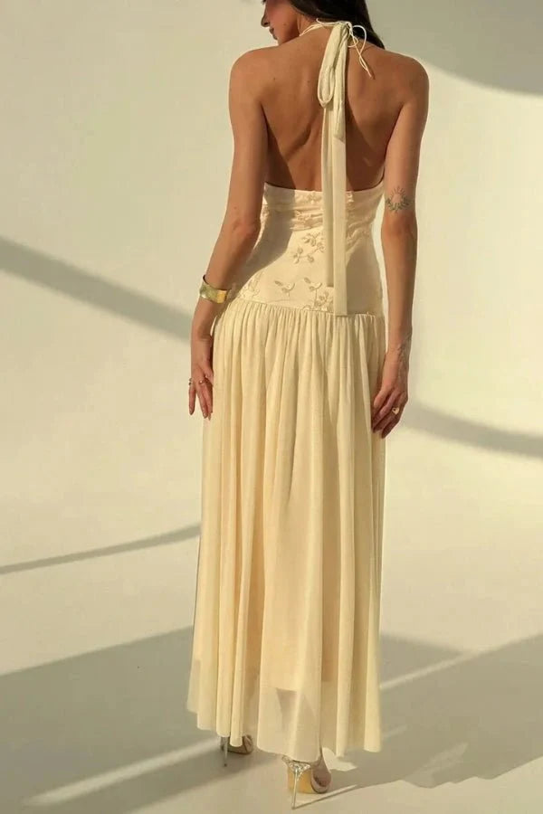 Model wearing the Kouvr Fashion Zoe yellow embroidered halter gown with open back