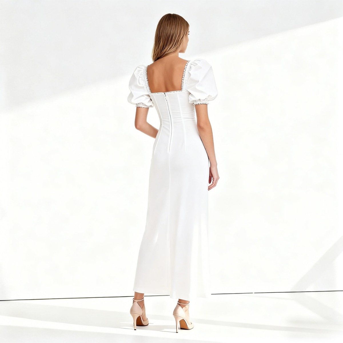 Woman wearing a white dress with puff sleeves on a white background