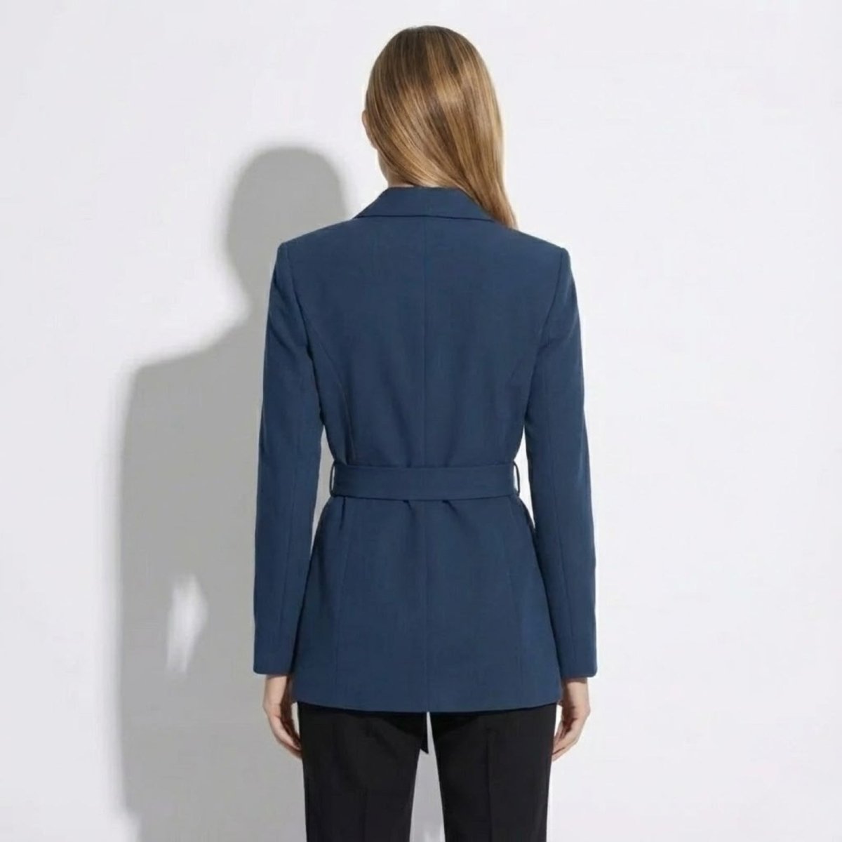 Back view of the Kouvr Gemma blazer in blue, highlighting the belt detail and clean lines of the tailoring.