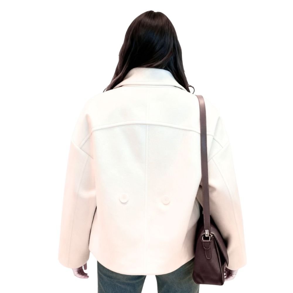 Back view of the Kouvr ivory cropped wool jacket on a model, showing the clean back yoke seam and two decorative lower buttons.