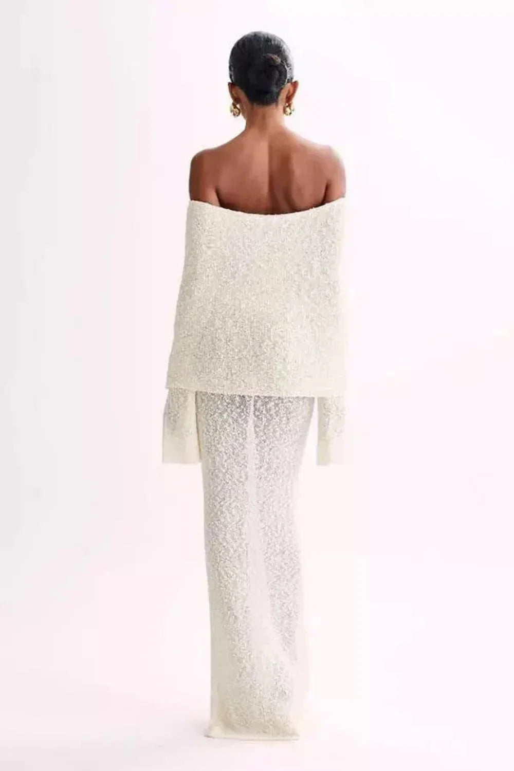 Model wearing Kouvr's ivory off-the-shoulder knit maxi gown, front view