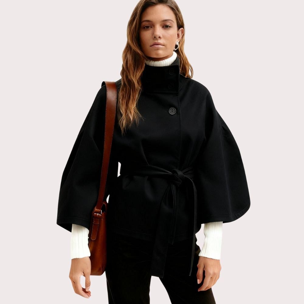 Model wearing the black Kouvr Jaye Cape Jacket, showcasing the tie-back belt and wide kimono sleeves
