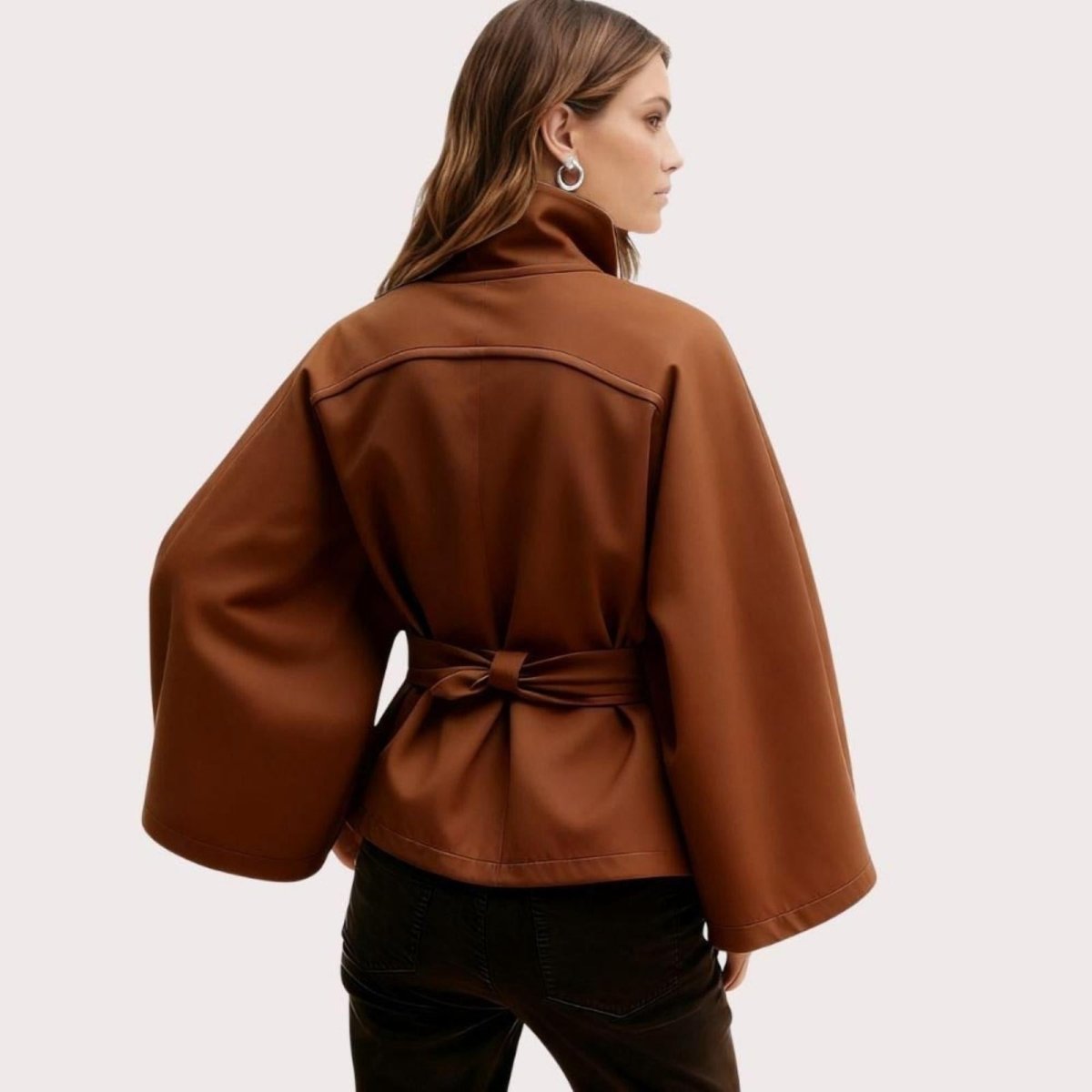 Model wearing Kouvr Fashion belted cape jacket with funnel neck and wide kimono sleeves