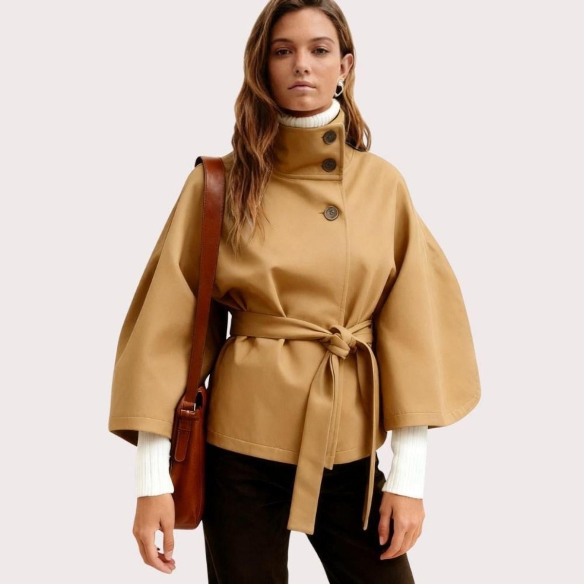 Model wearing Kouvr Fashion belted cape jacket with funnel neck and wide kimono sleeves