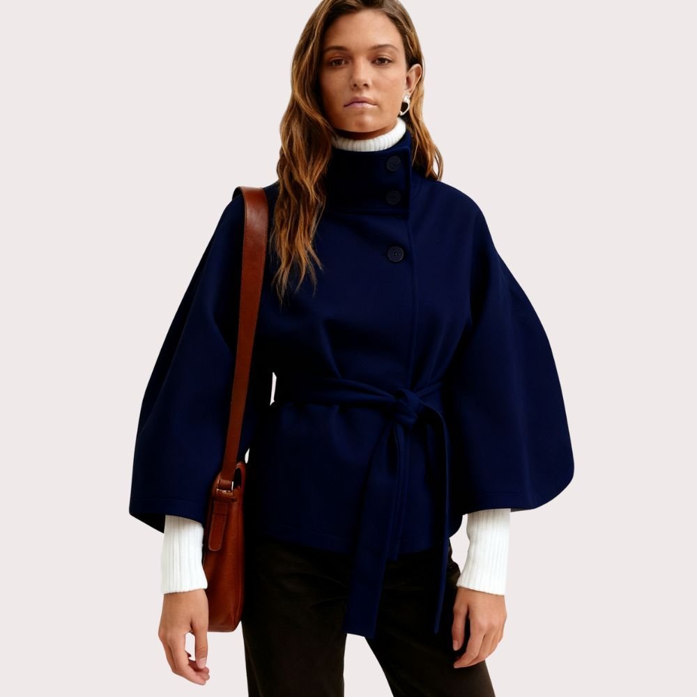 Model wearing Kouvr Fashion belted cape jacket with funnel neck and wide kimono sleeves