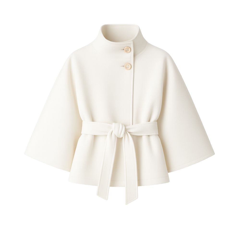 Model facing forward wears the Kouvr Jaye white wool belted cape coat with a high funnel neck and wide kimono sleeves