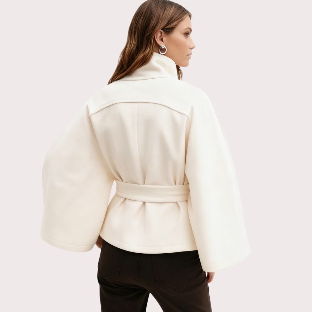 Model wearing Kouvr Fashion belted cape jacket with funnel neck and wide kimono sleeves