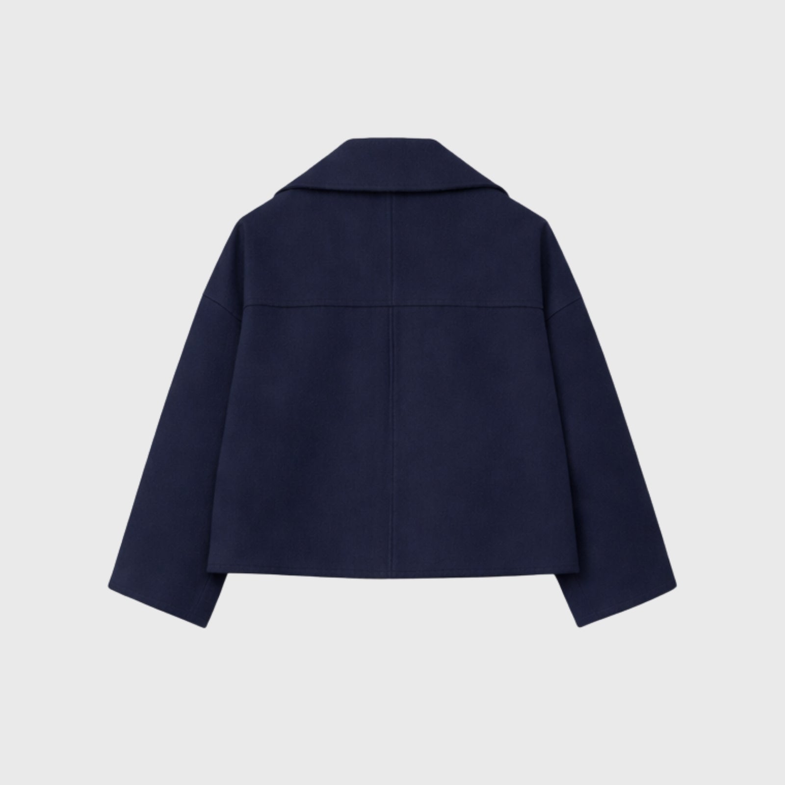 Studio flatlay of the back of the Kouvr Katherine navy peacoat, showing the precision tailoring and rich texture of the Italian wool.