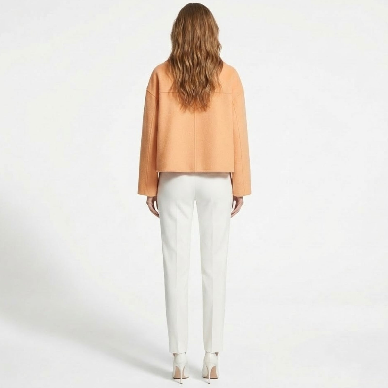 Product flat lay of the double-breasted Kouvr Claudia cropped wool jacket in peach, highlighting the texture of the fabric and button details.