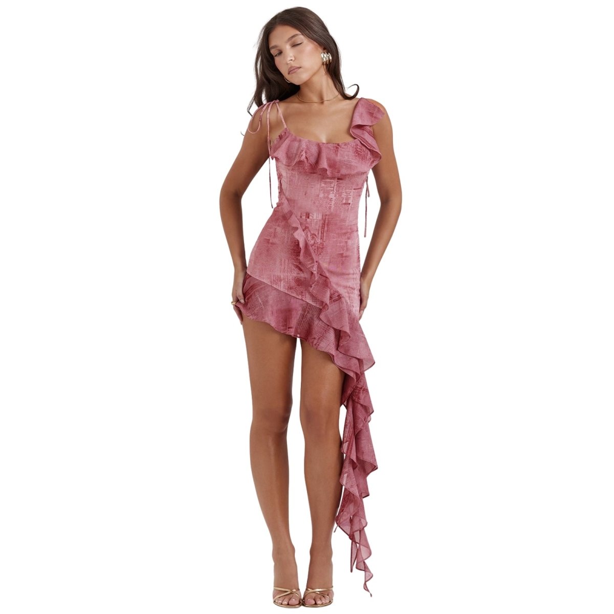 Woman wearing a pink kouvr ruffled dress on a white background