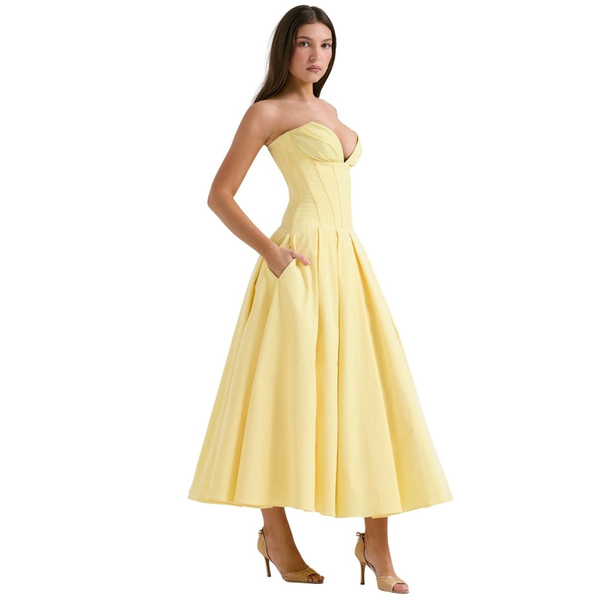 Woman wearing a yellow strapless dress on a white background