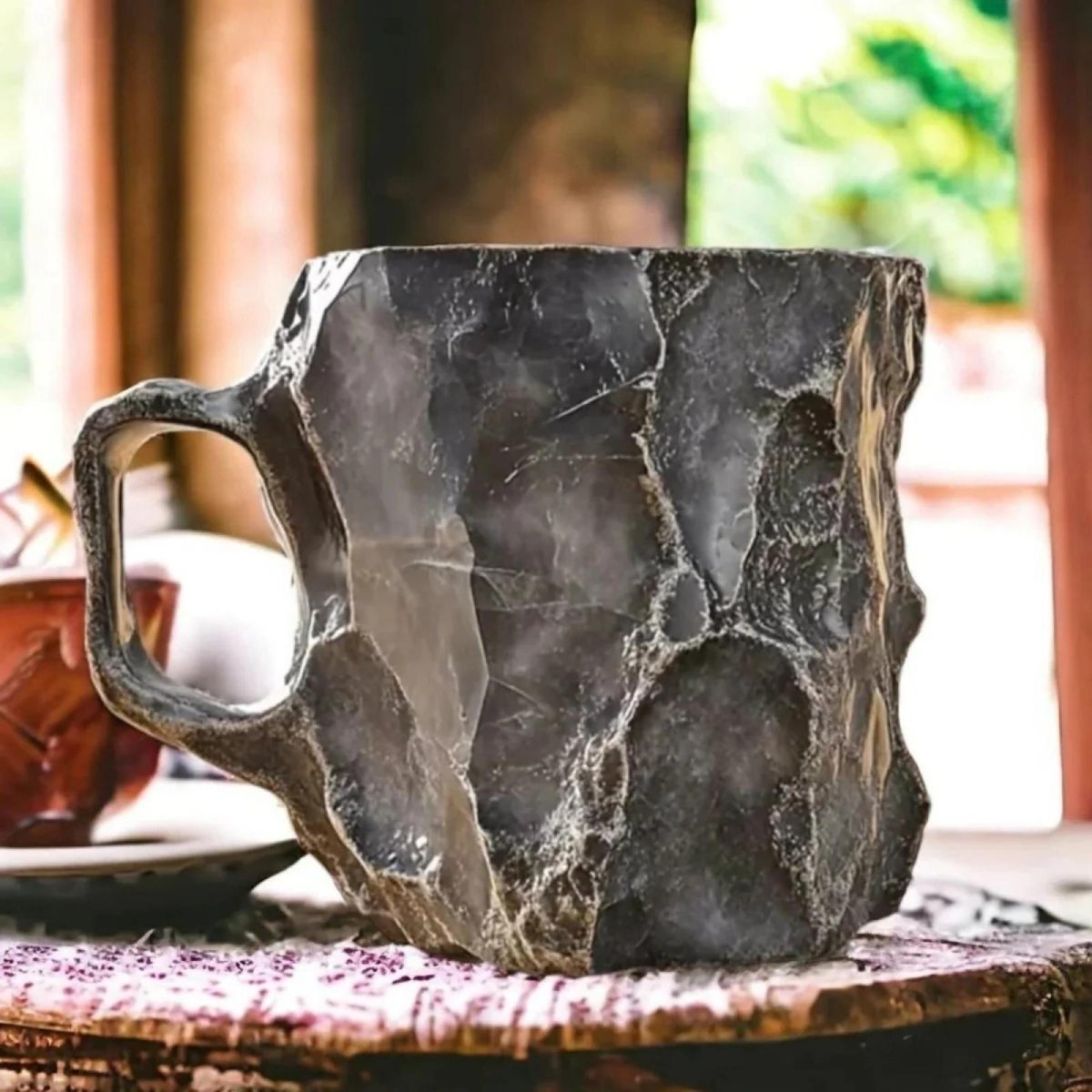 Close-up detail shot of the rugged, veined texture on a large 16oz handcrafted stone coffee mug by Kouvr.
