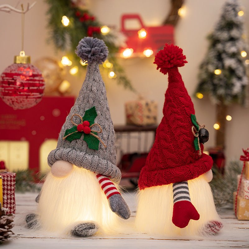 Close-up of two glowing Kouvr holiday gnome figurines holding hands, highlighting the texture of their knit hats and soft, illuminated beards.