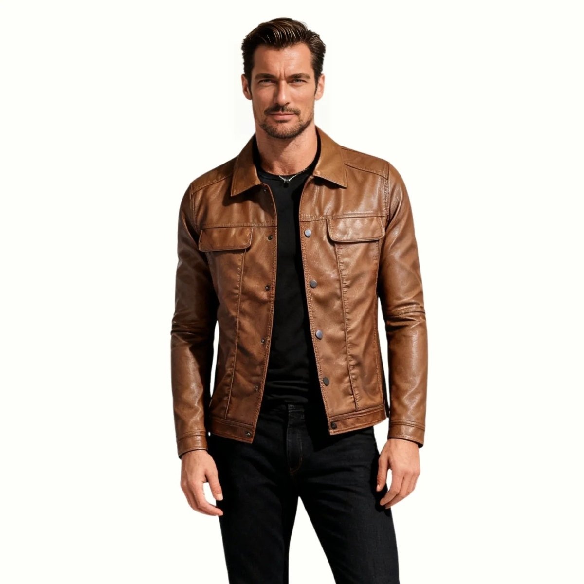 Male model facing forward wearing the Kouvr brown leather trucker jacket over a black t-shirt and black jeans against a white background.