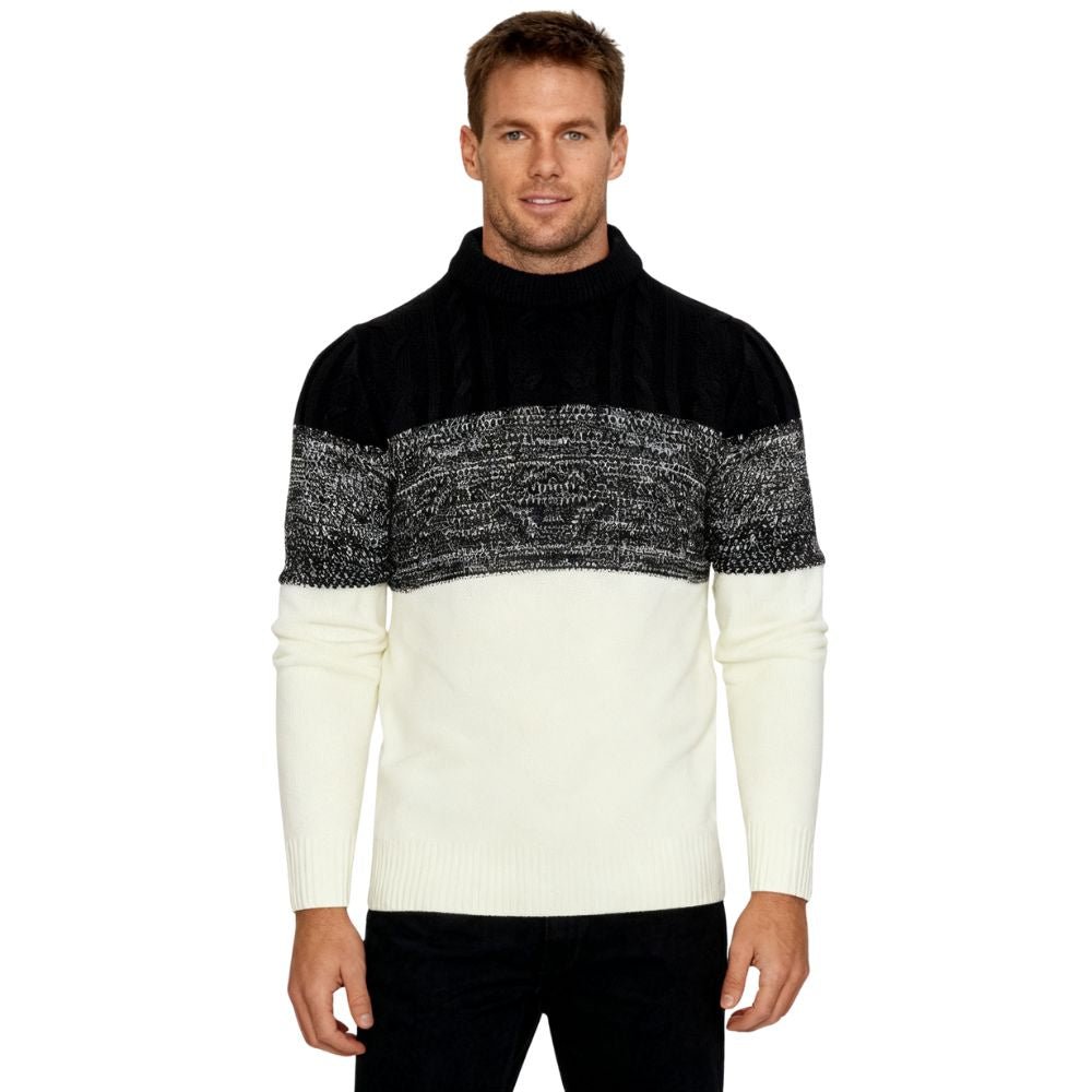 A man wearing the Kouvr color block turtleneck sweater in black, textured grey, and cream, paired with black trousers.