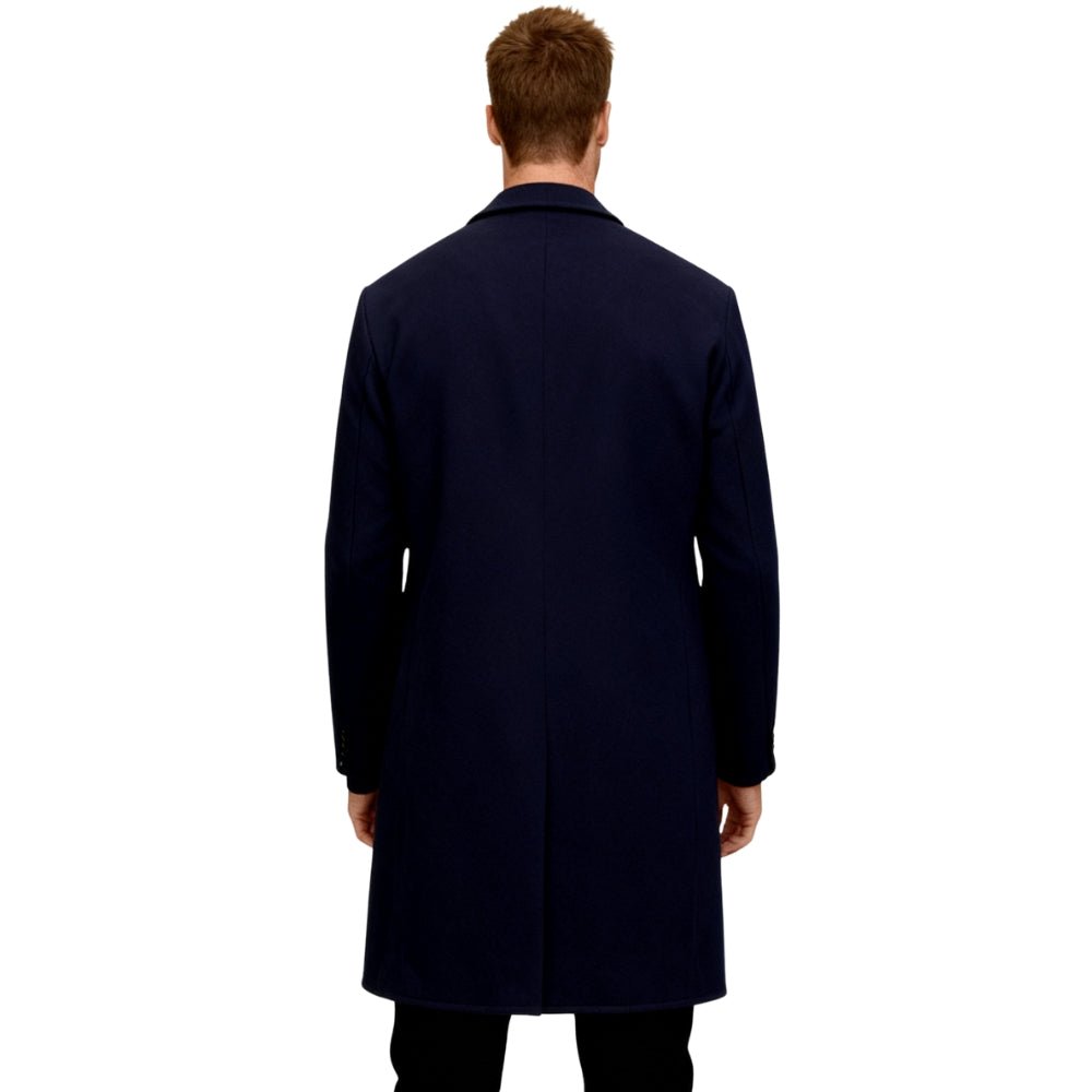 Man wearing a navy Kouvr overcoat on a white background