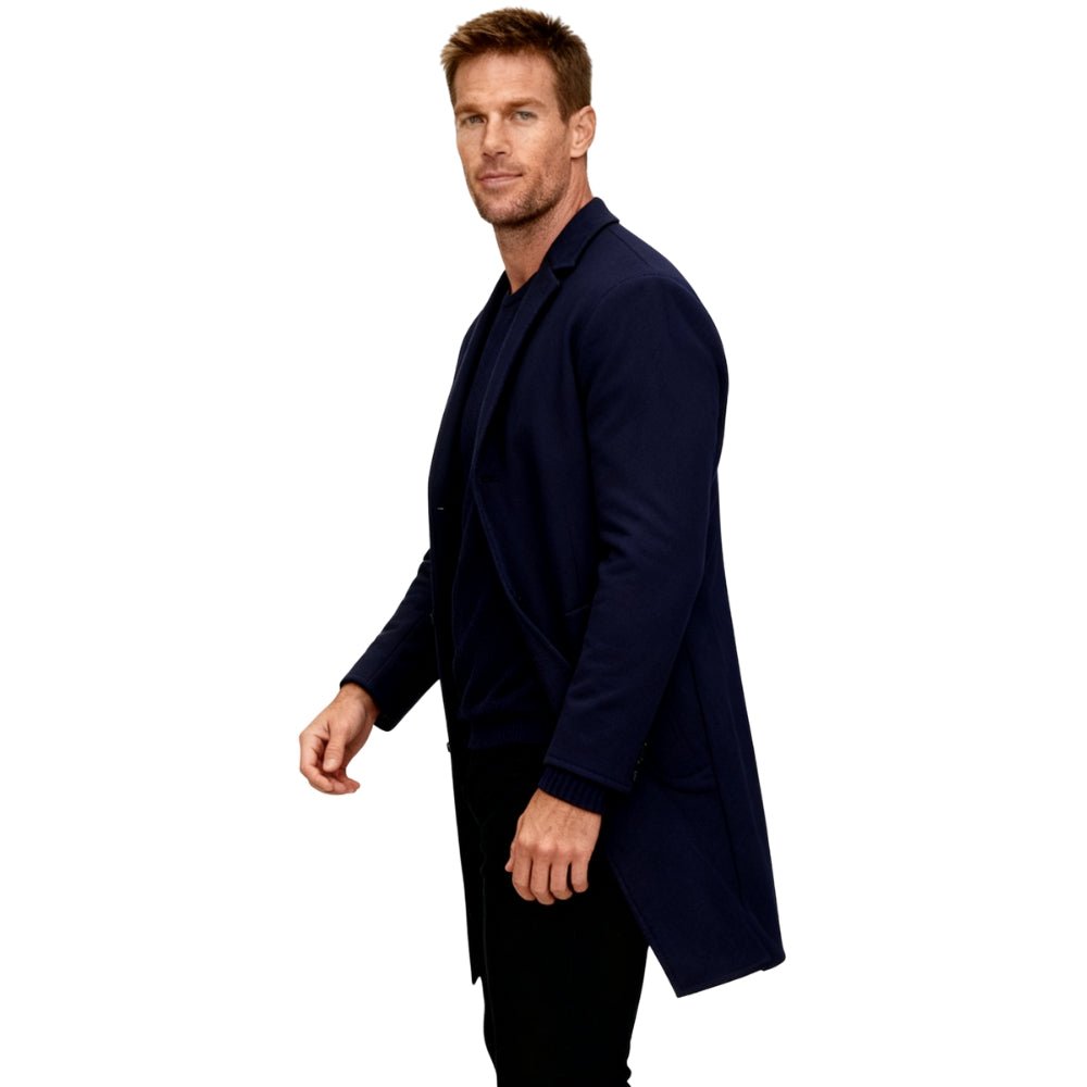 Man wearing a navy Kouvr blazer on a white background
