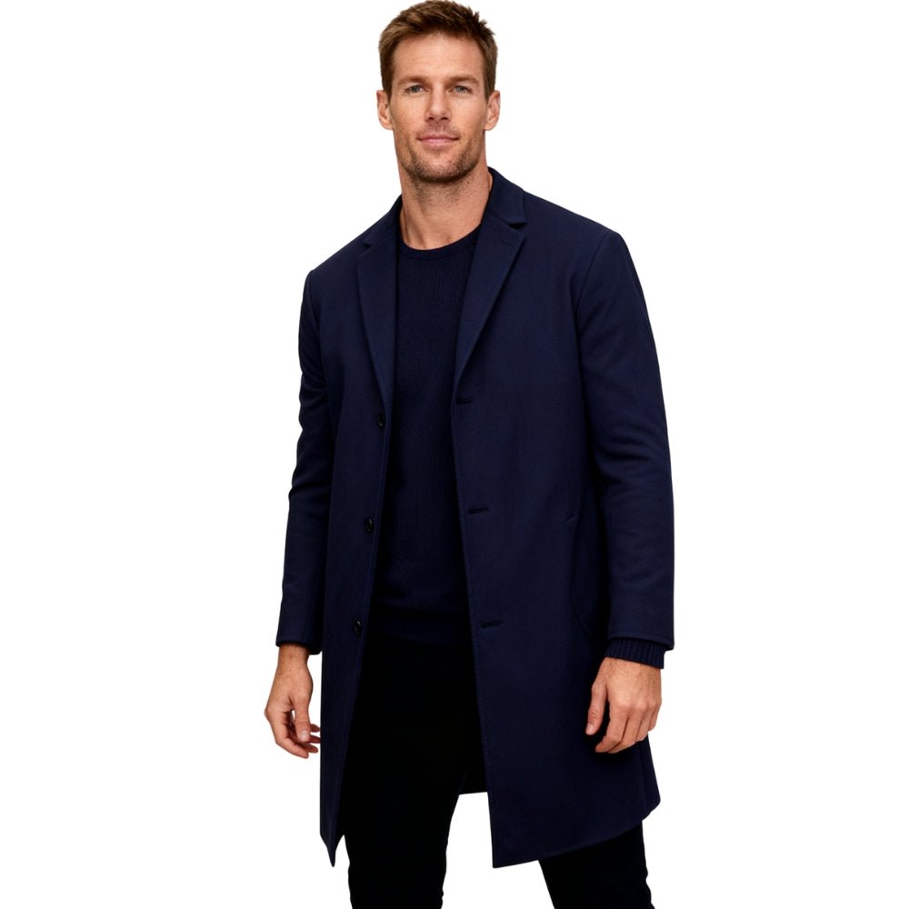Man wearing a navy Kouvr coat on a white background