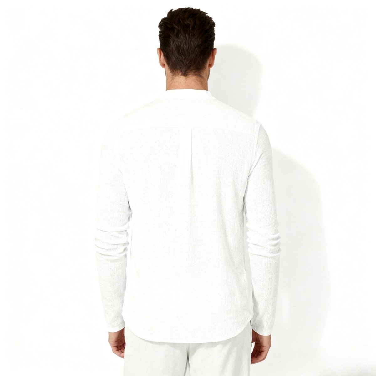 Back view of a man wearing the Kouvr white long-sleeve roby, showcasing the fit and back yoke detail.