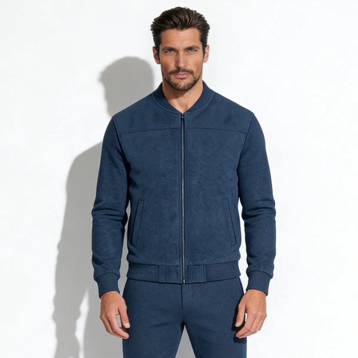 Model wearing the Kouvr Michael men's suede bomber jacket in slate blue, showing the full-zip front and tailored fit.