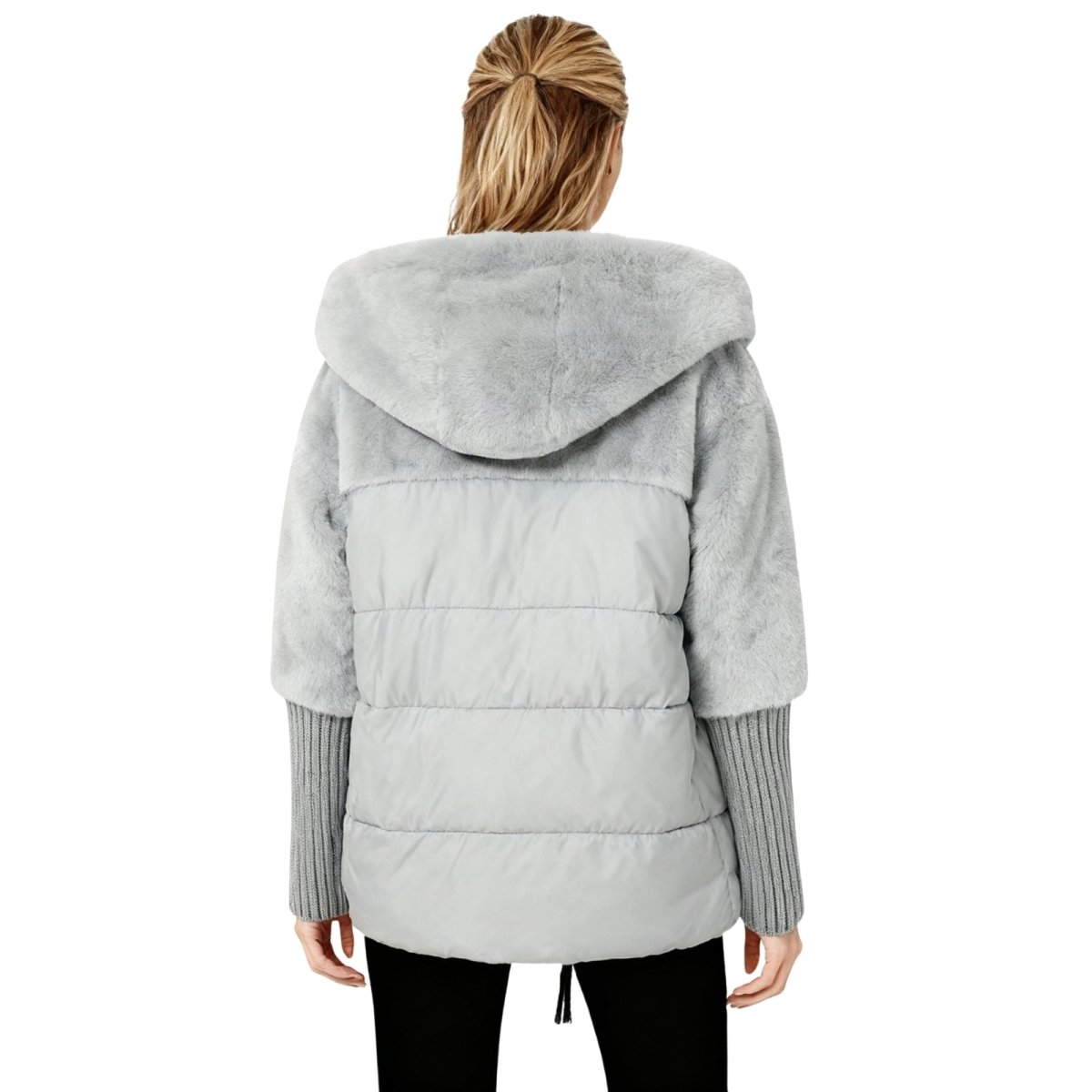 Person wearing a gray kouvr puffer jacket with a hood on a white background