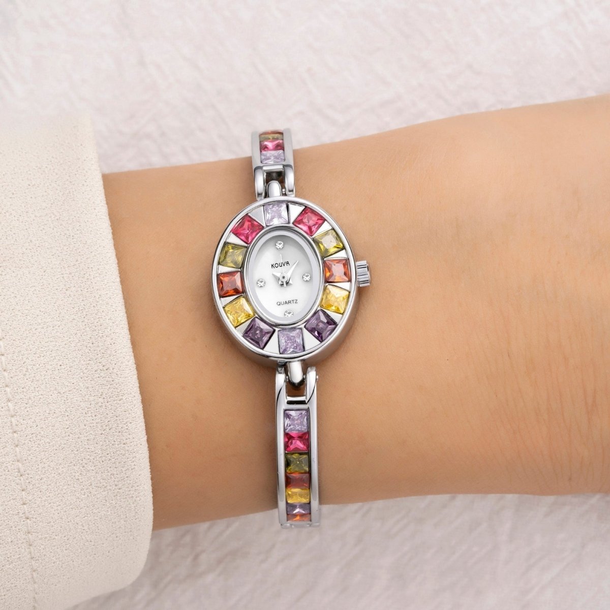 Kouvr Wrist wearing a colorful gemstone watch on a light background