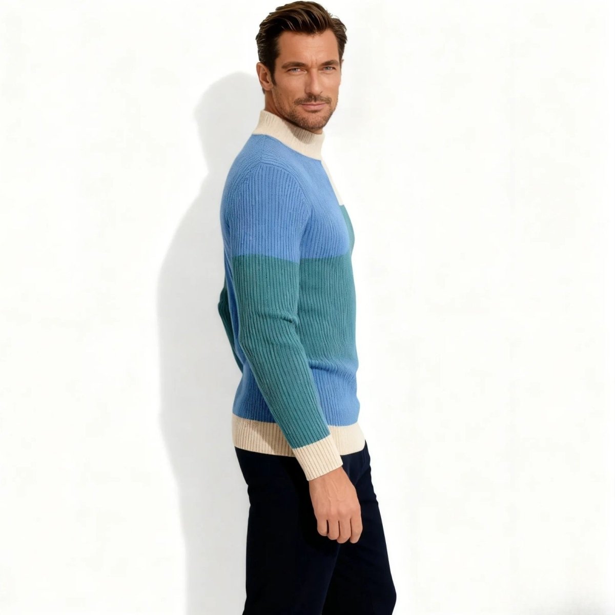 Side profile of a man in a slim fit Kouvr Nerthus ribbed knit sweater showing the color block pattern on the sleeve and body.