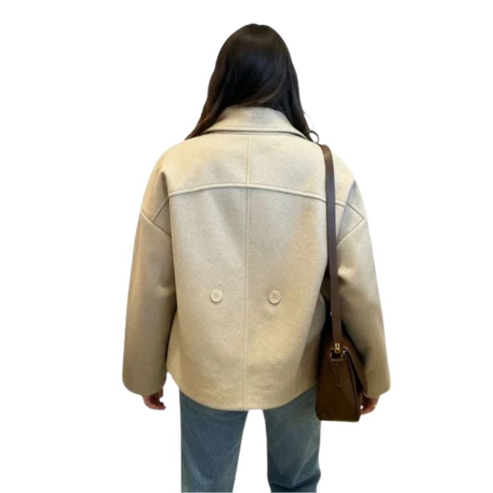 Back view of the Kouvr black cropped wool jacket on a model, showing the clean back yoke seam and two decorative lower buttons.