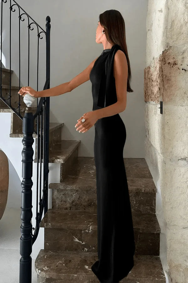 Model wearing Kouvr Fashion black one shoulder evening gown standing on marble staircase.