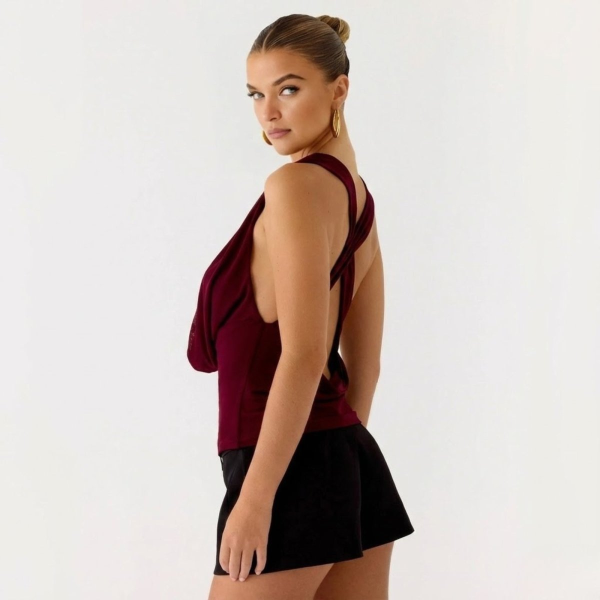 Back view of the Kouvr Rhea top showing the open back design with criss-cross straps in a rich burgundy color.